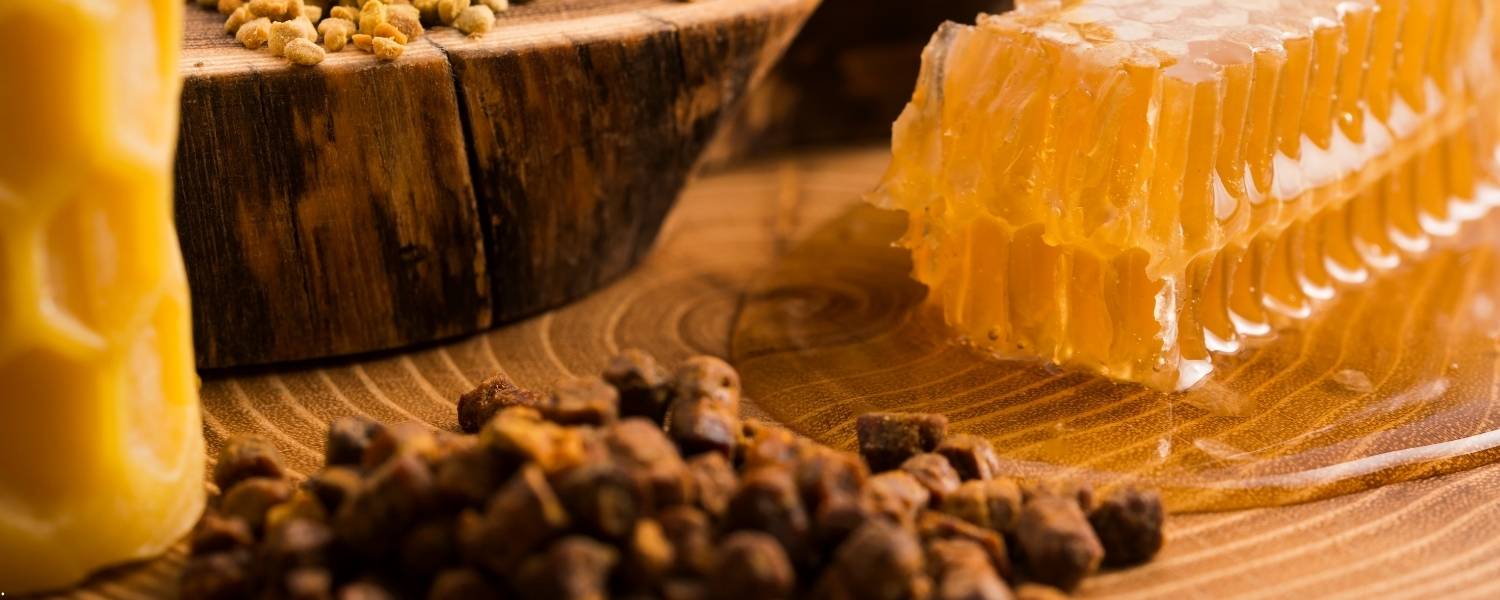 Image de miel et de propolis posés sur une table en bois