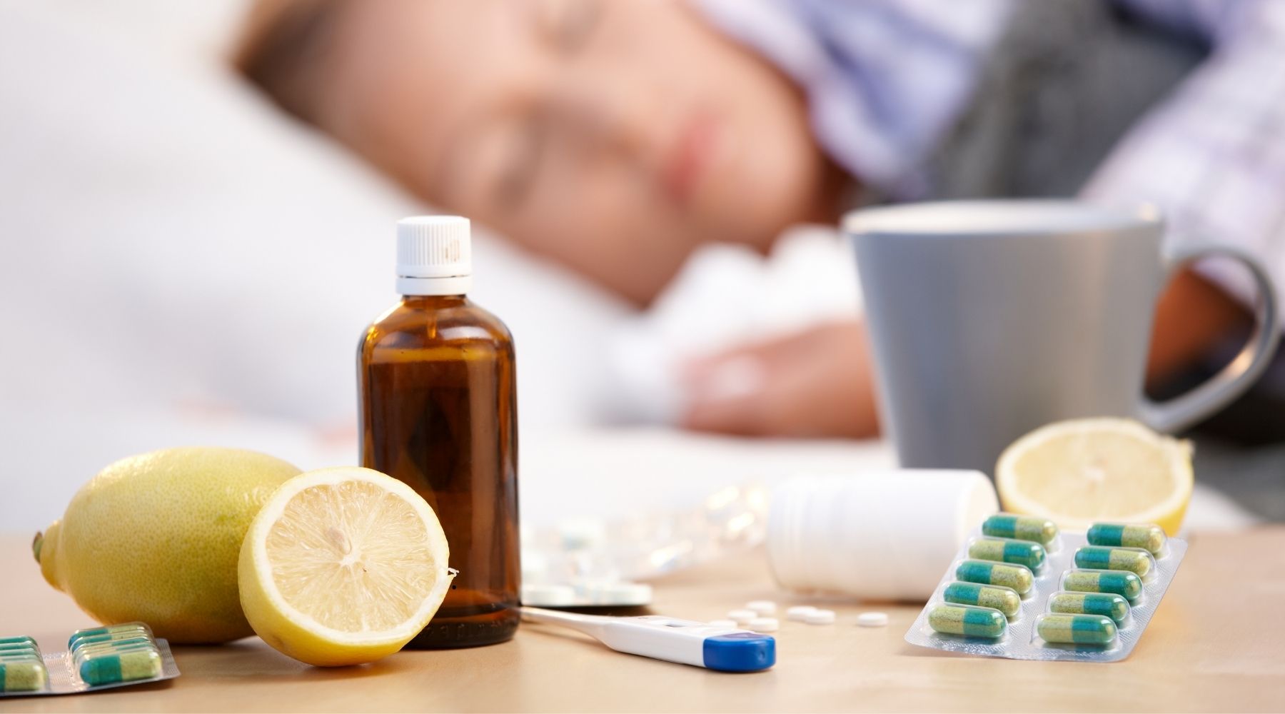 Une femme en train de dormir avec des vitamines posées sur sa table de chevet