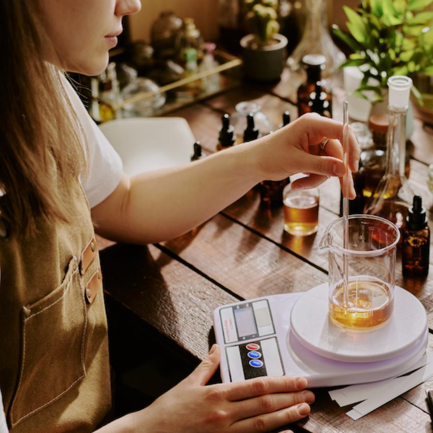 Une femme préparant des huiles essentielles sur un bureau