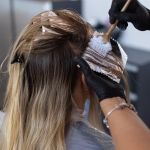 Une femme en train de se teindre les cheveux