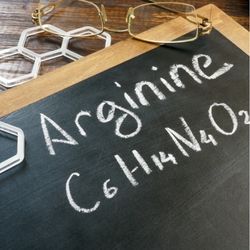 Une ardoise sur laquelle est inscrit à la craie blanche le mot "Arginine"