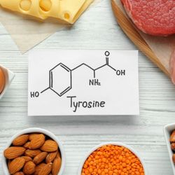 Une feuille de papier au milieu d'aliments, sur laquelle il est inscrit le mot "Tyrosine"