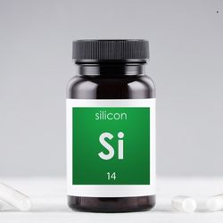 Flacon noir étiqueté 'Silicon Si 14', symbolisant des compléments alimentaires riches en silicium, avec des gélules blanches en arrière-plan.