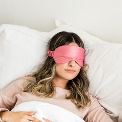 Une femme allongée dans un lit avec bandeau cache-lumière sur les yeux