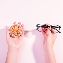 Photos de compléments alimentaires tenus dans la main gauche, et une paire de lunette tenue dans la main droite