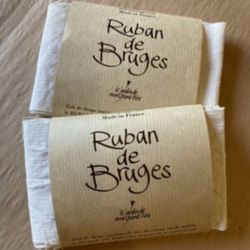 Deux paquets de ruban de bruges posés sur une table