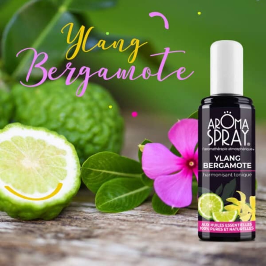 Un flacon de 100 ml d'Aromaspray Ylang Bergamotte avec une fleur d'ylag et de la bergamotte