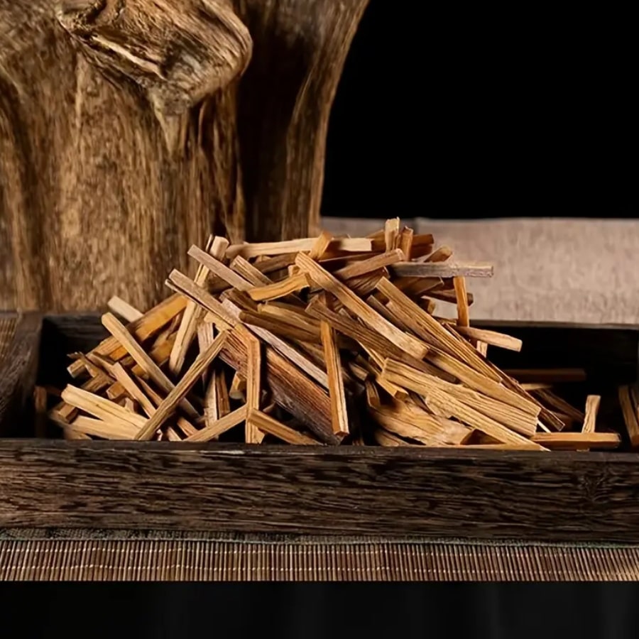 Des Bâtonnets de Bois de Palo Santo Parfumés au Bois de Santal disposé en vrac dans plateau en bois naturel