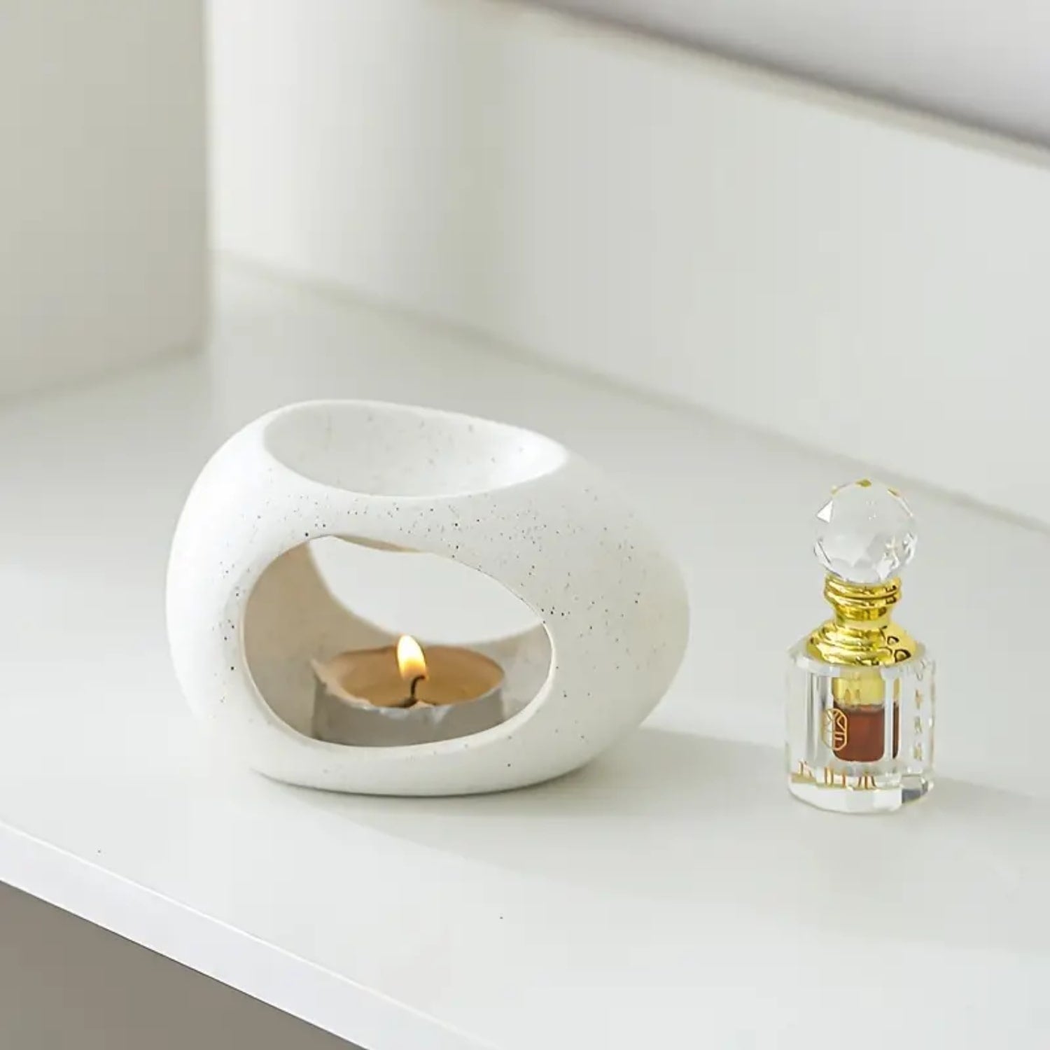 Un diffuseur de parfum naturel pour la maison au design moderne et minimaliste avec un flacon d'huiles essentielles posé à côté