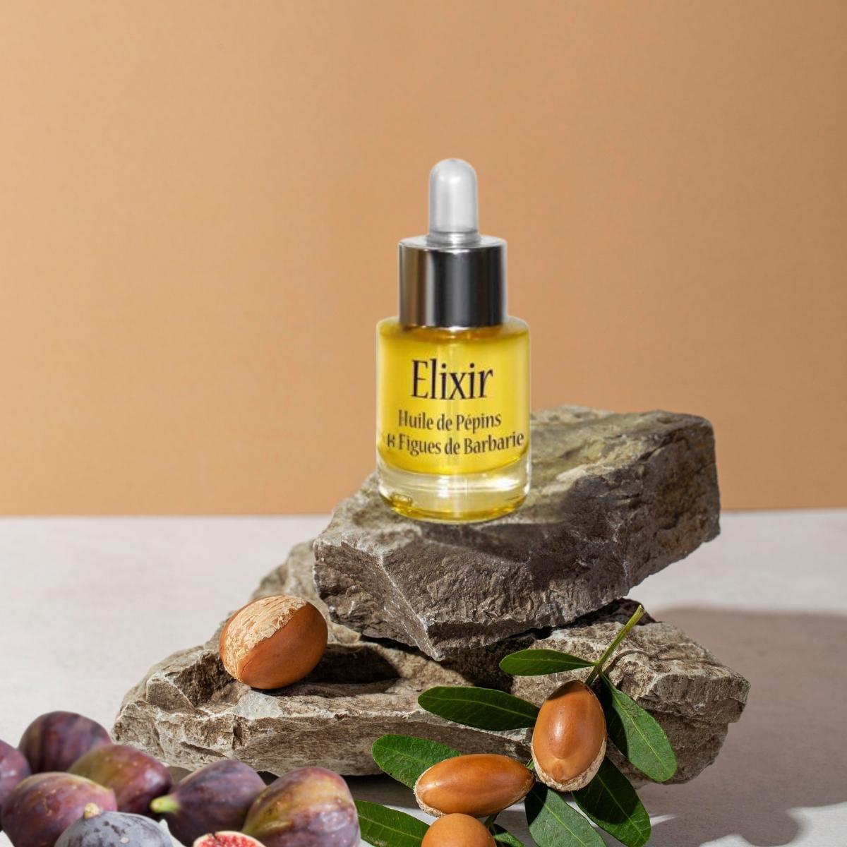 Un Elixir Huile de Pépins de Figues de Barbarie Véritable Bio  Arc en Sels posé sur une pierre devant des figues