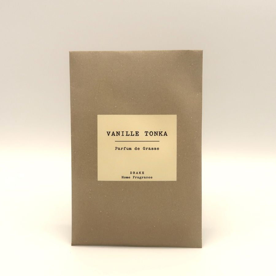 Une enveloppe parfumée à la vanille tonka de la marque Drake sur fond beige