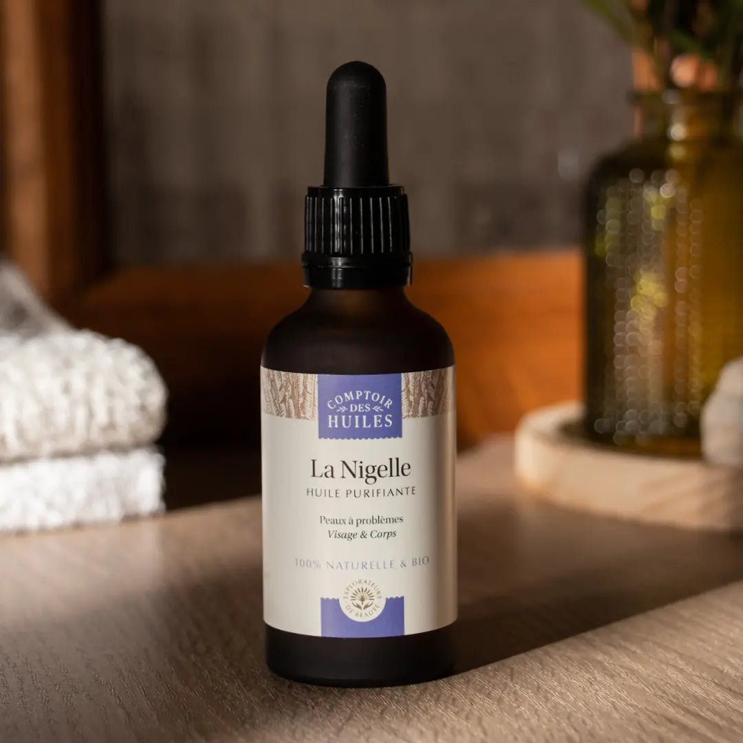 Un flacon de 50 ml d'Huile de Nigelle Bio Purifiante Comptoir des huiles posé sur une table