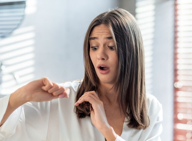 Photo d'une femme surprise découvrant que ses cheveux se cassent