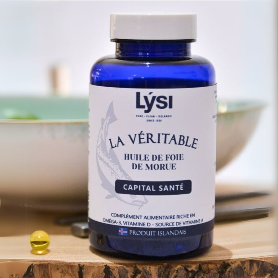 Une boite de Véritable Huile de Foie de Morue de 120 capsules de la marque Lysi, posée sur un rondin en bois