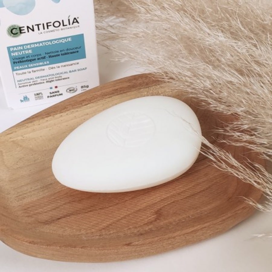 Un pain dermatologique neutre de 85 g de la marque Centifolia posé sur un porte savon en bois